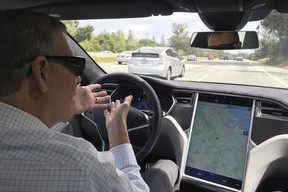 Reuters journalist Paul Ingrassia sits in the drivers seat of a Tesla Model S in Autopilot mode in San Francisco, California, U.S., April 7, 2016.